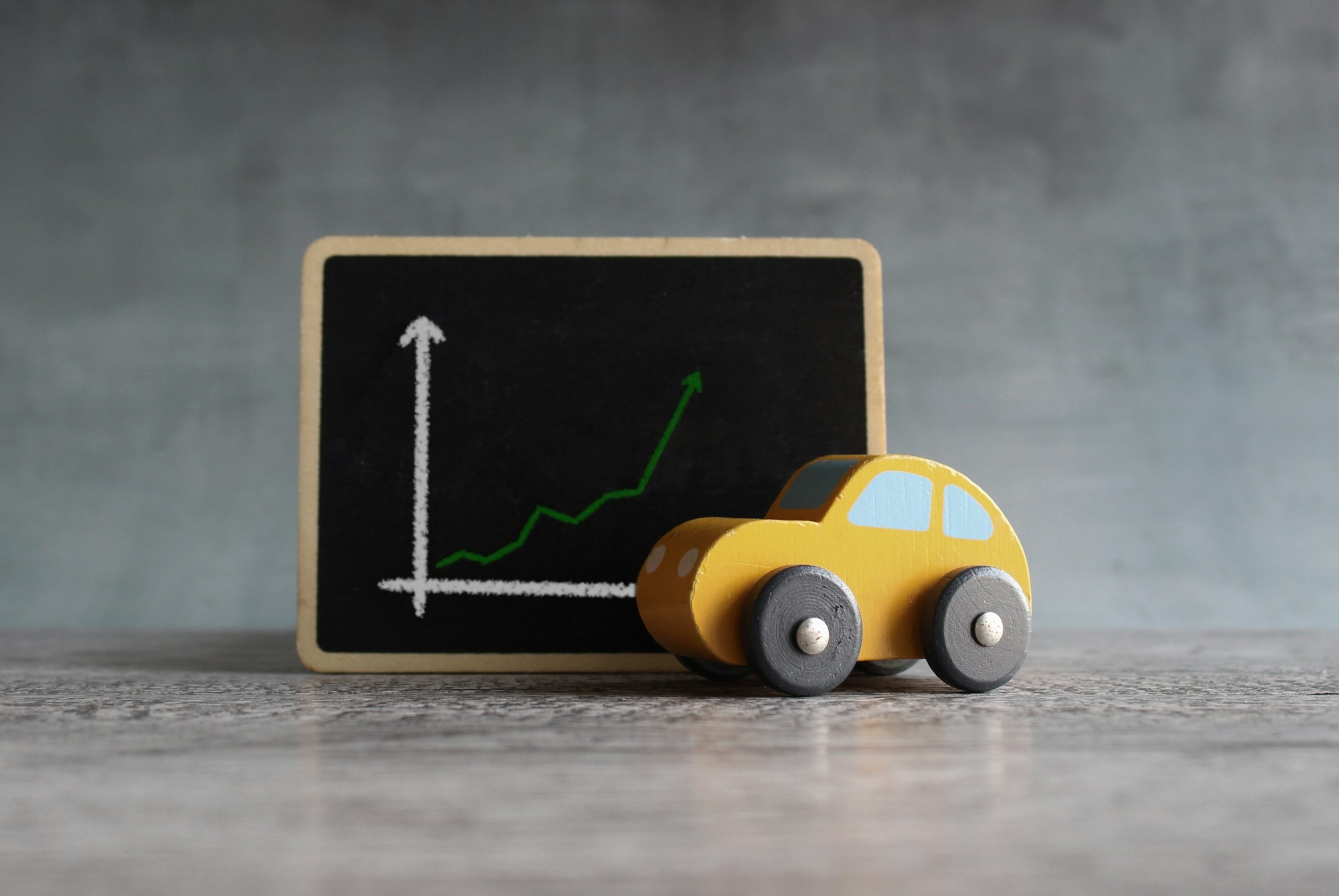 Toy car and chalkboard with upward arrow graph.